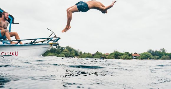 Eco-friendly Diving. - Man Wearing Blue Shorts Performing Back Flip over Body of Water