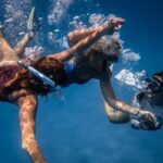 Diving Safety. - Group of young people with special equipment enjoying time together underwater with bubbles of oxygen