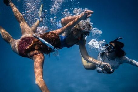 Diving Safety. - Group of young people with special equipment enjoying time together underwater with bubbles of oxygen