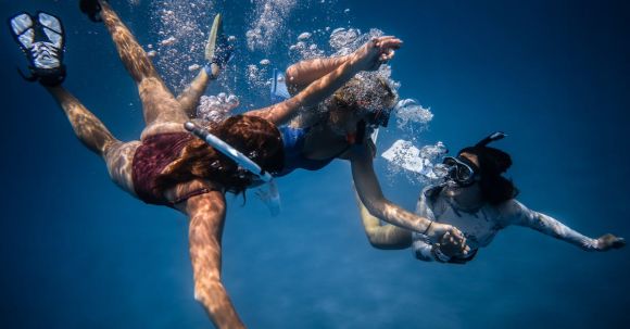 Diving Safety. - Group of young people with special equipment enjoying time together underwater with bubbles of oxygen