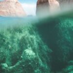 Underwater Geology. - Magnificent view of stony cliffs under transparent water of ocean in sunny summer