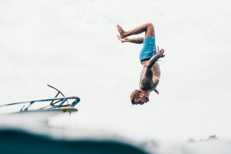 Best Dive Sites - Man Wearing Blue Shorts About to Dive on Body of Water