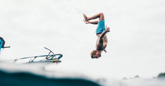 Best Dive Sites - Man Wearing Blue Shorts About to Dive on Body of Water