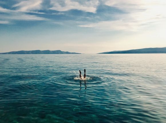 Dive - person in blue water during daytime