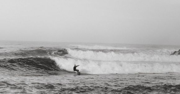 Wetsuit - Black and white side view of anonymous sportsman on surfboard practicing extreme sport on foamy ocean