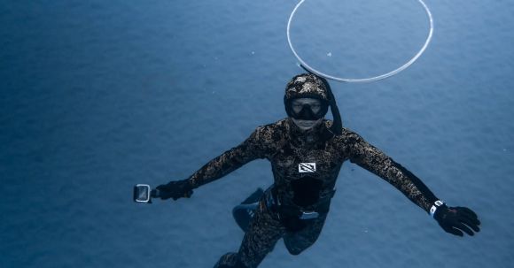 Wetsuit - Unrecognizable person diving in blue seawater