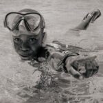 Diving Mask - A Boy Wearing a Diving Mask Swimming in the Water