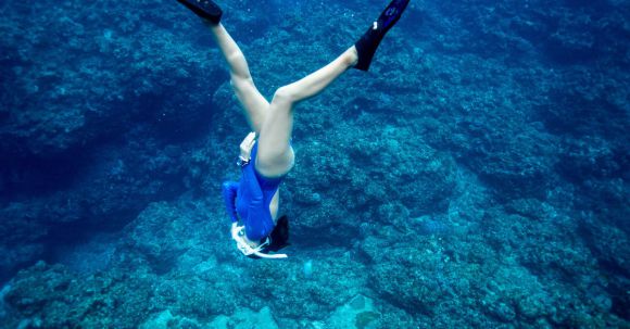 Snorkeling - A Woman Diving Towards the Sea Floor