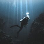 Scuba Tank - Scuba diver swimming near rocks