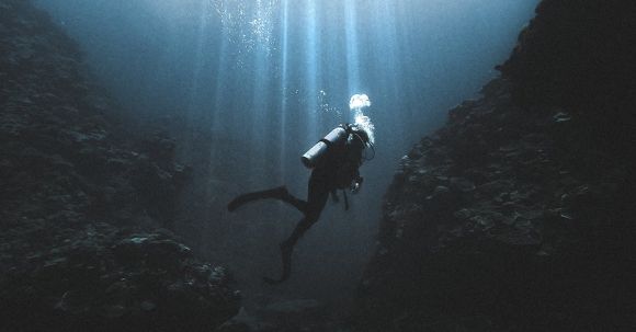 Scuba Tank - Scuba diver swimming near rocks