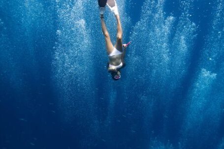 Snorkel - Unrecognizable lady swimming underwater after jumping in ocean