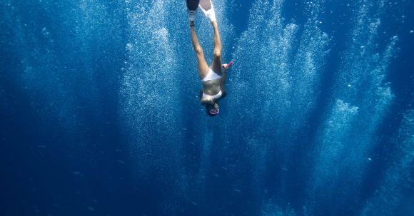 Snorkel - Unrecognizable lady swimming underwater after jumping in ocean