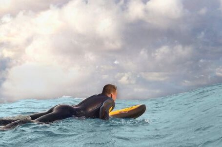 Wetsuit - Man Surfing on Sea Waves Under White Clouds