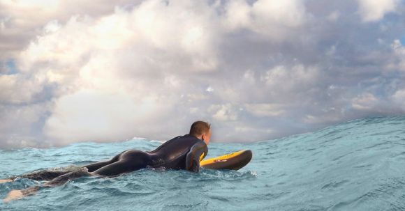 Wetsuit - Man Surfing on Sea Waves Under White Clouds