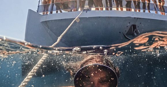 Diving Boat - Woman Underwater Taking a Picture of Herself and People on a Boat behind Her