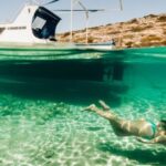 Diving Boat - Woman Snorkelling Next to a Small Boat 