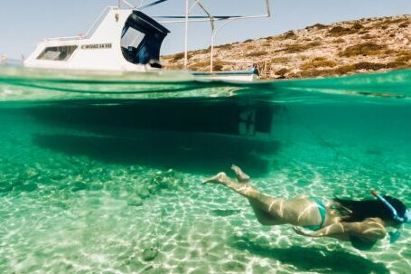 Diving Boat - Woman Snorkelling Next to a Small Boat 