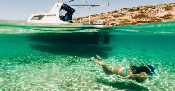 Diving Boat - Woman Snorkelling Next to a Small Boat 