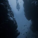Diving Locations - Diver swimming between rocks