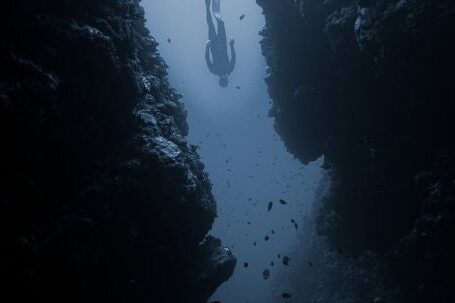 Diving Locations - Diver swimming between rocks