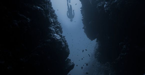 Diving Locations - Diver swimming between rocks