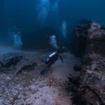 Shipwrecks For Diving - Scuba Divers with Equipment Swimming near Shipwreck Underwater