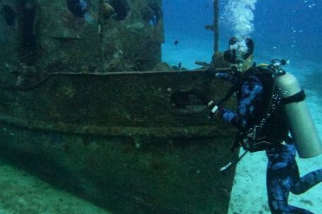 Diving Boat - A Scuba Diver Near a Sunken Boat Underwater