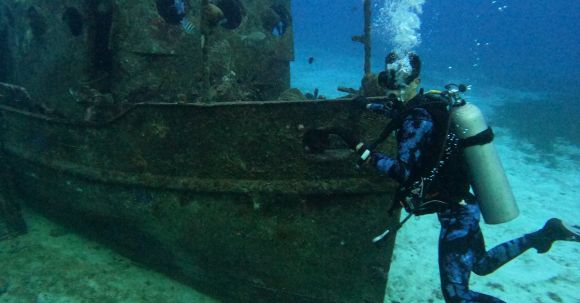 Diving Boat - A Scuba Diver Near a Sunken Boat Underwater