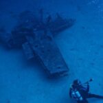 Underwater - Photo of Person Scuba Diving Near Wreckage