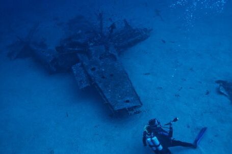 Underwater - Photo of Person Scuba Diving Near Wreckage