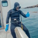 Scuba Diving - Person in Scuba Diving Gear Sitting on a Boat