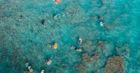 Snorkeling - Sunbathers Swimming on Air Mattresses in Sea at Coral Reef