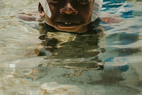 Diving Mask - A Boy Wearing a Diving Mask Swimming in the Water