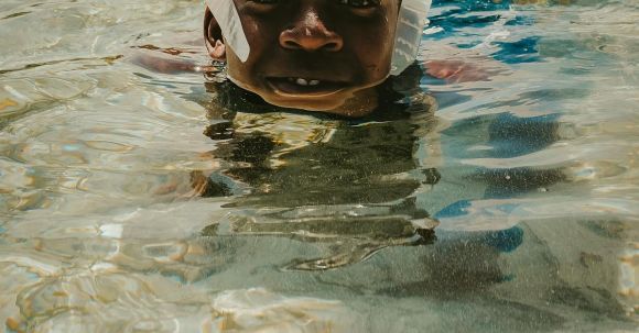 Diving Mask - A Boy Wearing a Diving Mask Swimming in the Water