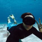 Snorkeling - Man in Clothes and Flippers Swimming Underwater
