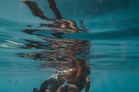 Snorkeling - Two People Wearing Flippers Swimming Underwater