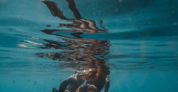 Snorkeling - Two People Wearing Flippers Swimming Underwater