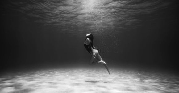 Shipwrecks For Diving - Black and White Photo of Woman Swimming Underwater 