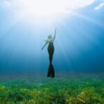 Scuba Diving - a woman standing in the middle of a grassy field