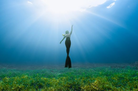 Scuba Diving - a woman standing in the middle of a grassy field