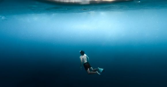 Snorkeling - Underwater View of a Man Snorkeling Near the Surface