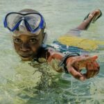 Diving Mask - A Boy Wearing a Diving Mask Swimming in the Water