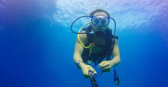 Diving - Man Carrying Air Tank in Body on Water