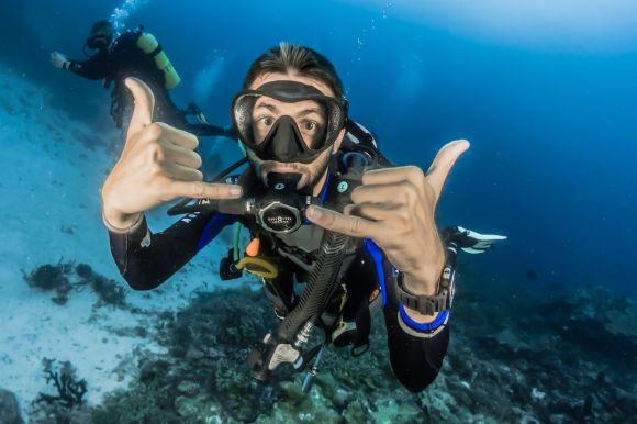 Diving - man underwater making hand signs