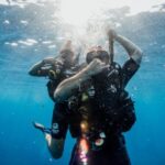 Scuba Diving - man in black wetsuit diving on water