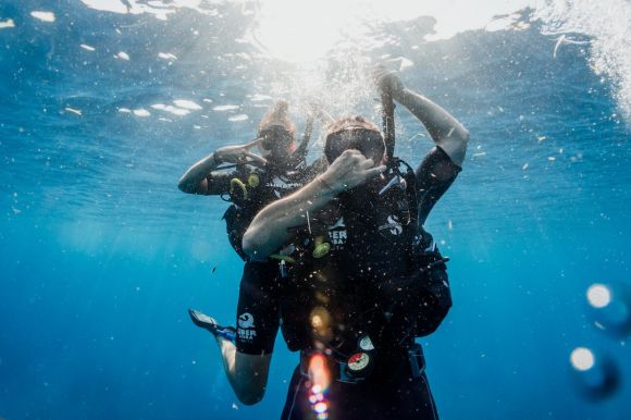 Scuba Diving - man in black wetsuit diving on water