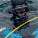 Scuba Diving - Scuba Diver on Water Surface Holding a Sea Urchin