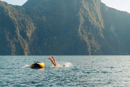 Diving Boat - A Person Diving into the Water from a Little Boat