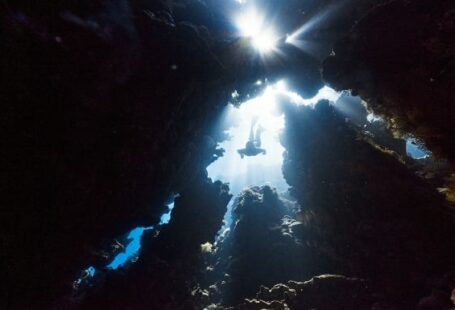 Diving - the sun shines through the water in a cave