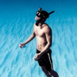 Snorkel - Unrecognizable man snorkeling in azure seawater